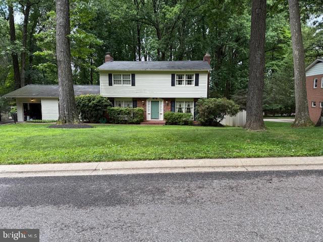 4 Burr Oak Ct, Randallstown, MD 21133 - view of front facade featuring a chimney and a front yard