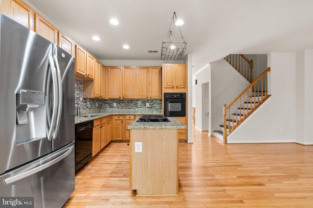 9956 Fragrant Lilies Way, Laurel, MD 20723 - kitchen with black appliances, light wood finished floors, a center island, decorative backsplash, and light stone counters