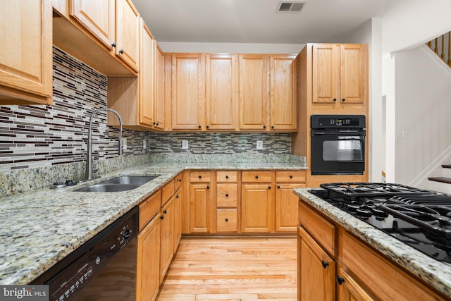 9956 Fragrant Lilies Way, Laurel, MD 20723 - kitchen with black appliances, light wood finished floors, decorative backsplash, and light stone counters
