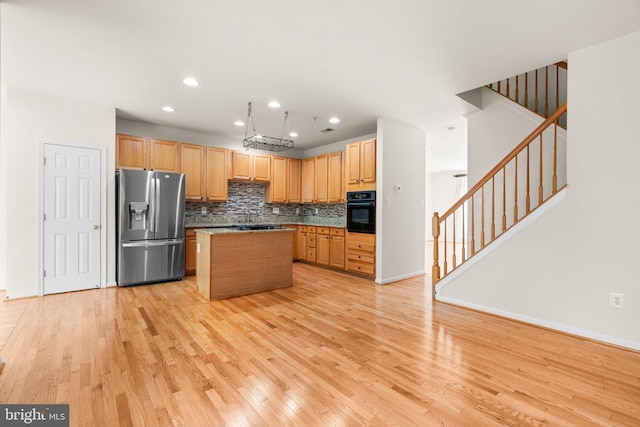9956 Fragrant Lilies Way, Laurel, MD 20723 - kitchen with stainless steel fridge, oven, light wood-style flooring, decorative backsplash, and a center island