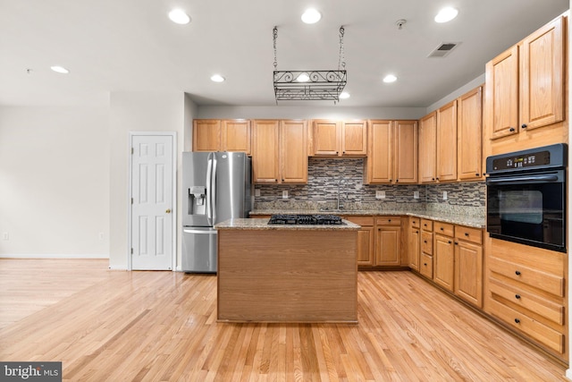 9956 Fragrant Lilies Way, Laurel, MD 20723 - kitchen with black oven, stainless steel fridge, gas stovetop, tasteful backsplash, and light wood finished floors