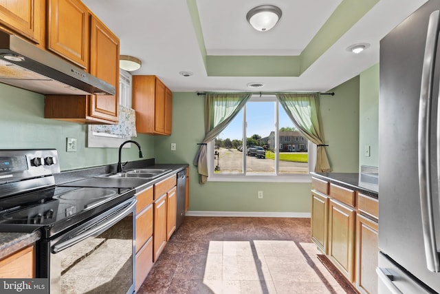 1142 Pheasant Dr N, Carlisle, PA 17013 - kitchen featuring appliances with stainless steel finishes, under cabinet range hood, a raised ceiling, dark countertops, and brown cabinetry