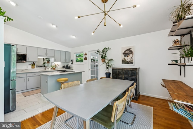 2307 Sherwood Hall Ln, Alexandria, VA 22306 - dining area featuring a chandelier, vaulted ceiling, and light wood-style flooring