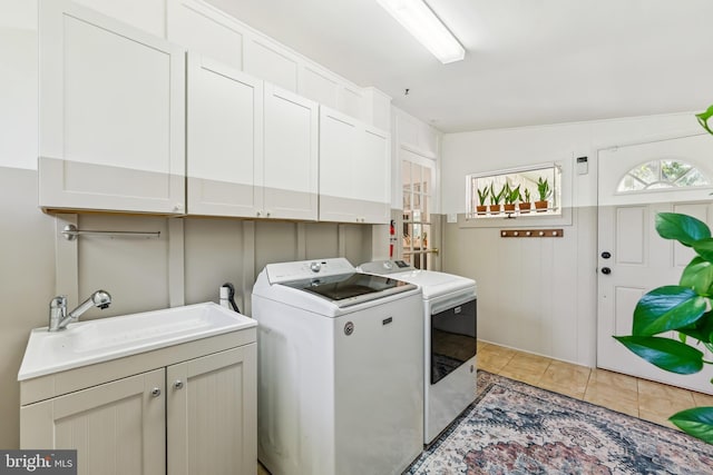 2307 Sherwood Hall Ln, Alexandria, VA 22306 - laundry room featuring washer and dryer, cabinet space, and light tile patterned floors