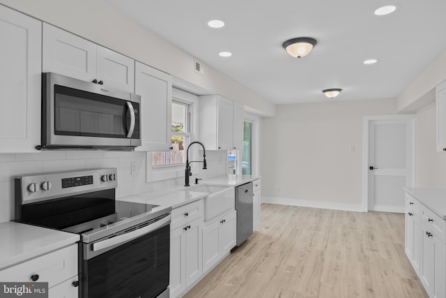 4 New Coach Ln, Willingboro, NJ 08046 - kitchen featuring appliances with stainless steel finishes, decorative backsplash, light countertops, white cabinets, and recessed lighting
