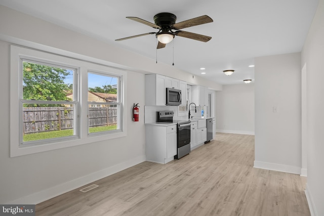 4 New Coach Ln, Willingboro, NJ 08046 - kitchen with appliances with stainless steel finishes, light countertops, white cabinets, light wood-style floors, and a ceiling fan
