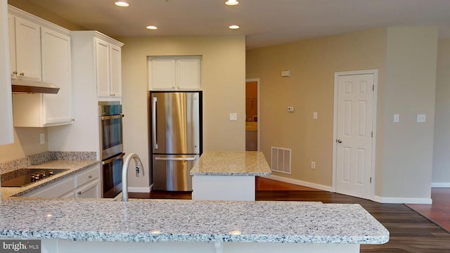 8117 Grayden Ln, Brandywine, MD 20613 - kitchen featuring stainless steel appliances, under cabinet range hood, recessed lighting, dark wood-type flooring, and light stone counters