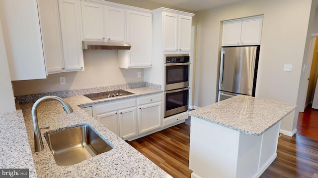 8117 Grayden Ln, Brandywine, MD 20613 - kitchen featuring appliances with stainless steel finishes, dark wood-style flooring, under cabinet range hood, white cabinetry, and light stone counters