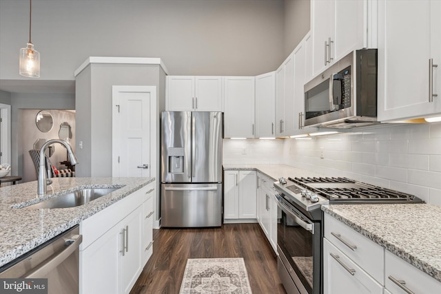 294 Letitia Manor Dr, West Grove, PA 19390 - kitchen with appliances with stainless steel finishes, tasteful backsplash, white cabinets, dark wood-style flooring, and light stone countertops