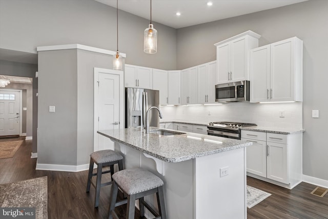 294 Letitia Manor Dr, West Grove, PA 19390 - kitchen with stainless steel appliances, backsplash, a kitchen breakfast bar, light stone countertops, and dark wood-type flooring