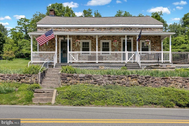 1124 Fairview Dr, Reading, PA 19605 - farmhouse inspired home with stone siding, covered porch, and a chimney