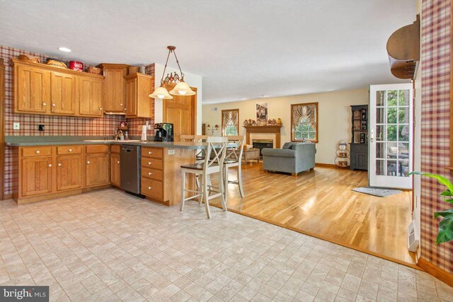148 S Allwood Dr, Hanover, PA 17331 - kitchen with dishwasher, a peninsula, open floor plan, a kitchen bar, and brown cabinets
