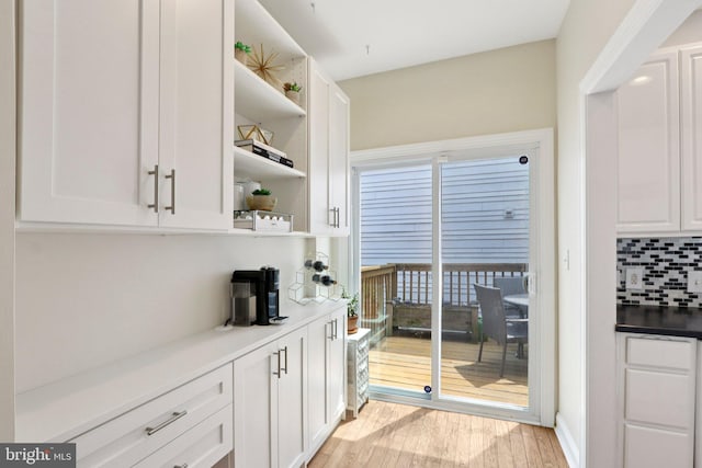 929 S 18th St, Philadelphia, PA 19146 - kitchen featuring open shelves, white cabinets, light wood-style floors, and tasteful backsplash