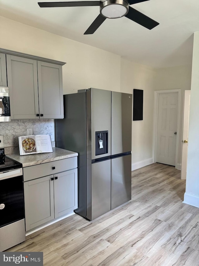 538 S Lime St, Lancaster, PA 17602 - kitchen featuring appliances with stainless steel finishes, gray cabinets, ceiling fan, backsplash, and light wood-style flooring