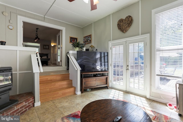 251 Kelly Dr, Harpers Ferry, WV 25425 - living room with french doors, a ceiling fan, light tile patterned flooring, a wood stove, and a decorative wall