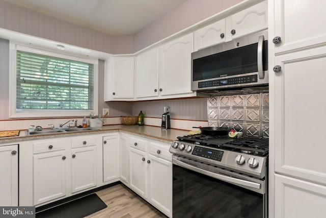 251 Kelly Dr, Harpers Ferry, WV 25425 - kitchen with appliances with stainless steel finishes, white cabinetry, light wood-style flooring, and backsplash