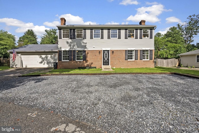 15321 Peach Orchard Rd, Silver Spring, MD 20905 - colonial-style house featuring a chimney, brick siding, a garage, and driveway