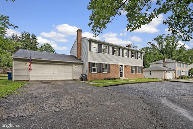 15321 Peach Orchard Rd, Silver Spring, MD 20905 - view of front of property featuring a chimney, brick siding, driveway, and a garage