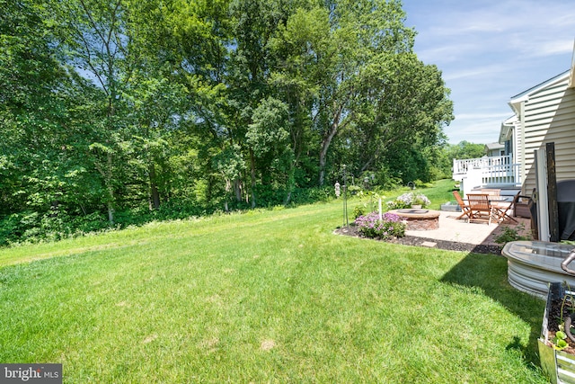 231 Lupine Dr, Smyrna, DE 19977 - view of green lawn with an outdoor fire pit, a patio, and a deck