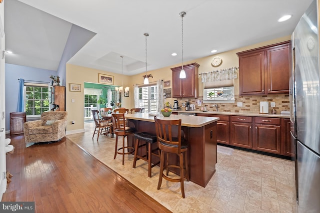 231 Lupine Dr, Smyrna, DE 19977 - kitchen featuring light countertops, freestanding refrigerator, a kitchen breakfast bar, a kitchen island, and plenty of natural light