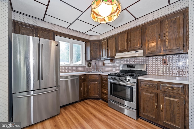 411 Parkstone Way, Broomall, PA 19008 - kitchen with appliances with stainless steel finishes, under cabinet range hood, light countertops, dark brown cabinets, and light wood-style floors