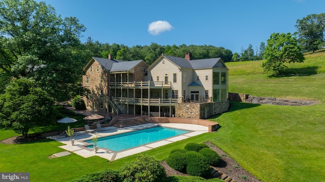 5751 Mount Pisgah Rd, York, PA 17406 - rear view of house with a yard, a patio area, stone siding, an outdoor pool, and a chimney