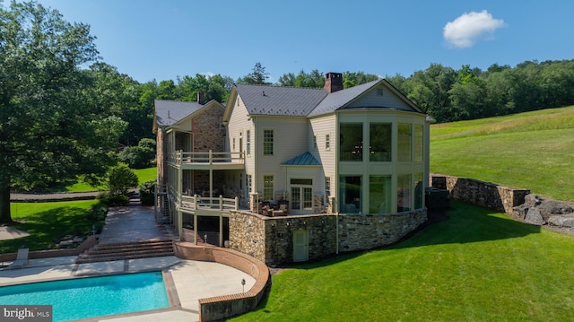 5751 Mount Pisgah Rd, York, PA 17406 - back of house with a balcony, stone siding, a patio, a yard, and a chimney