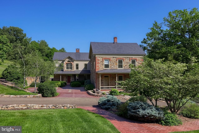 5751 Mount Pisgah Rd, York, PA 17406 - view of front of house with stone siding, covered porch, and a chimney