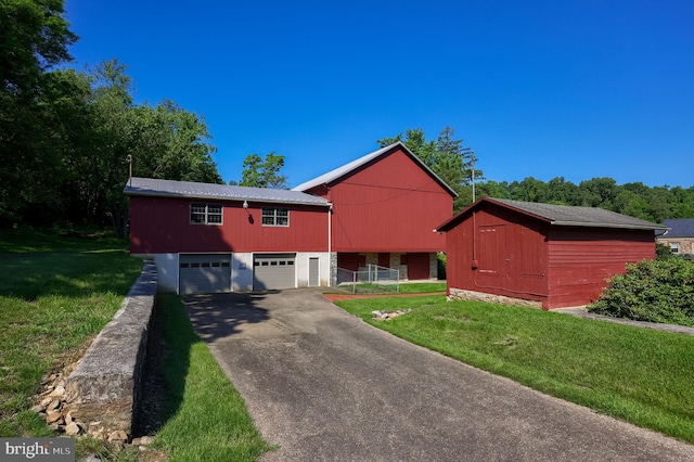 5751 Mount Pisgah Rd, York, PA 17406 - view of front of home with asphalt driveway, a front yard, a metal roof, and an outbuilding