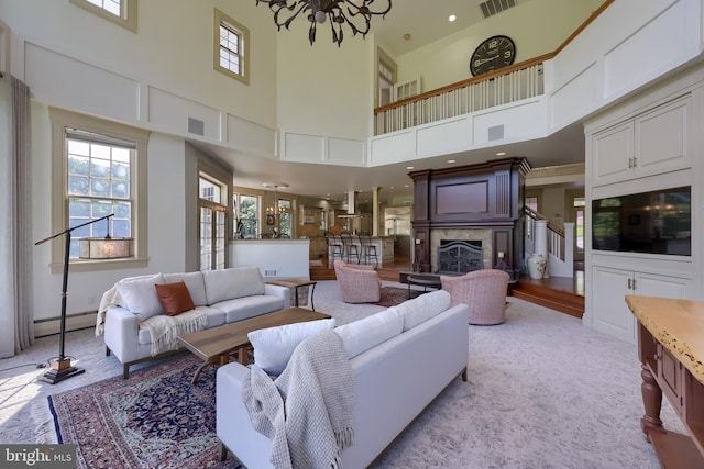 5751 Mount Pisgah Rd, York, PA 17406 - living area featuring a baseboard heating unit, a towering ceiling, a fireplace, and light carpet