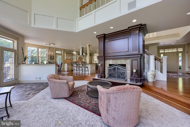 5751 Mount Pisgah Rd, York, PA 17406 - living room featuring wood finished floors, a towering ceiling, a high end fireplace, stairway, and a chandelier