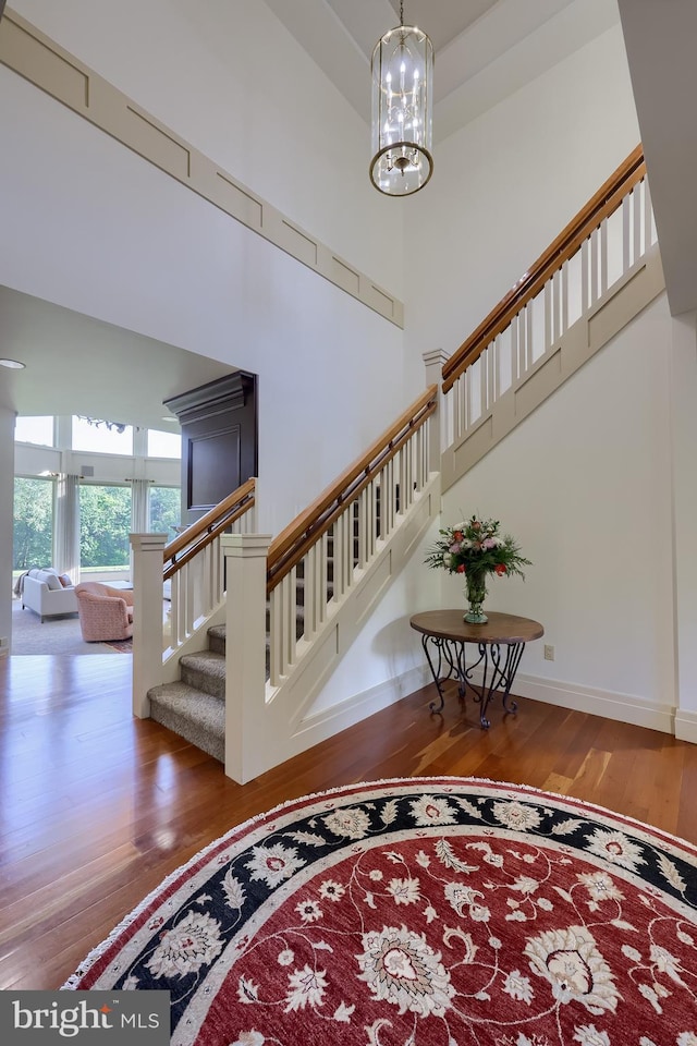 5751 Mount Pisgah Rd, York, PA 17406 - staircase featuring wood finished floors, a towering ceiling, and a chandelier