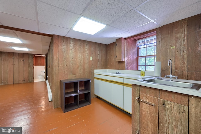 5751 Mount Pisgah Rd, York, PA 17406 - kitchen featuring wood walls, light countertops, light wood-type flooring, and a paneled ceiling