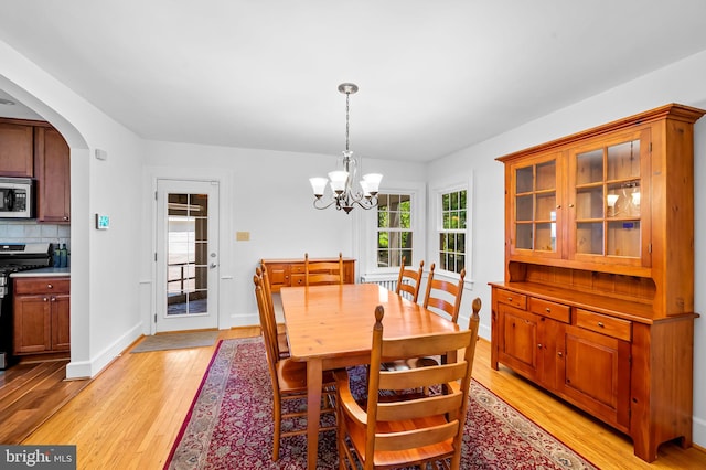 206 E Lake Ave, Baltimore, MD 21212 - dining room featuring light wood-style floors, a chandelier, and arched walkways