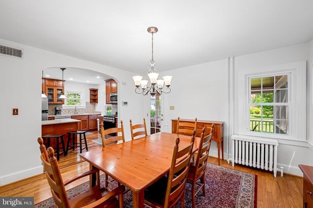 206 E Lake Ave, Baltimore, MD 21212 - dining room featuring radiator, arched walkways, a chandelier, light wood finished floors, and recessed lighting