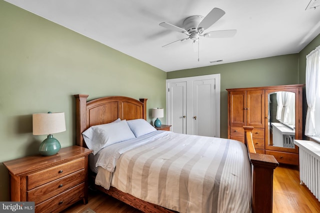 206 E Lake Ave, Baltimore, MD 21212 - bedroom with radiator heating unit, light wood-style floors, and ceiling fan