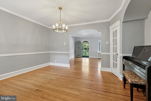 7527 Germantown Ave, Philadelphia, PA 19119 - spare room with arched walkways, light wood finished floors, a chandelier, and crown molding