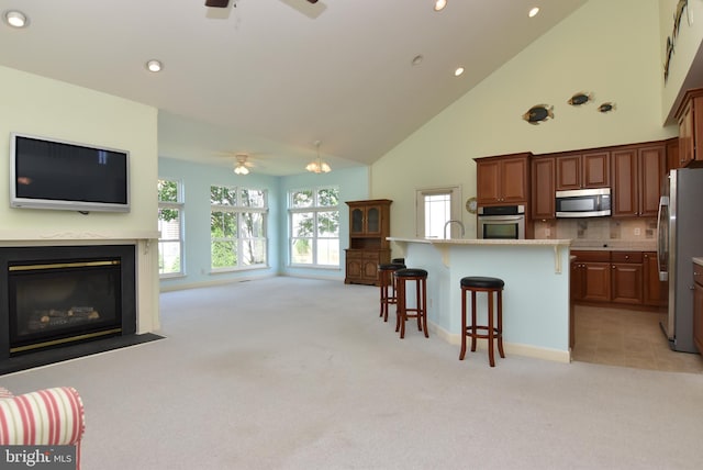 36765 Hummingbird Way N, Selbyville, DE 19975 - kitchen featuring appliances with stainless steel finishes, ceiling fan, light colored carpet, open floor plan, and a breakfast bar area