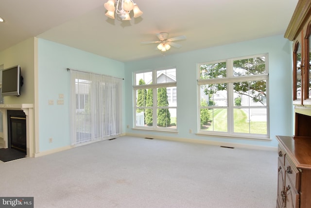 36765 Hummingbird Way N, Selbyville, DE 19975 - unfurnished living room featuring a glass covered fireplace, carpet floors, and ceiling fan