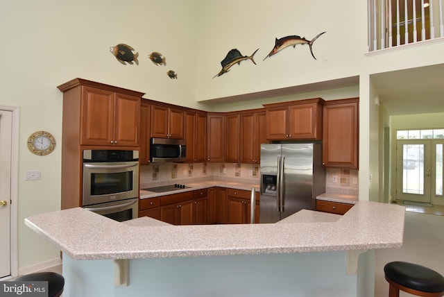 36765 Hummingbird Way N, Selbyville, DE 19975 - kitchen with appliances with stainless steel finishes, a towering ceiling, a kitchen breakfast bar, tasteful backsplash, and light countertops
