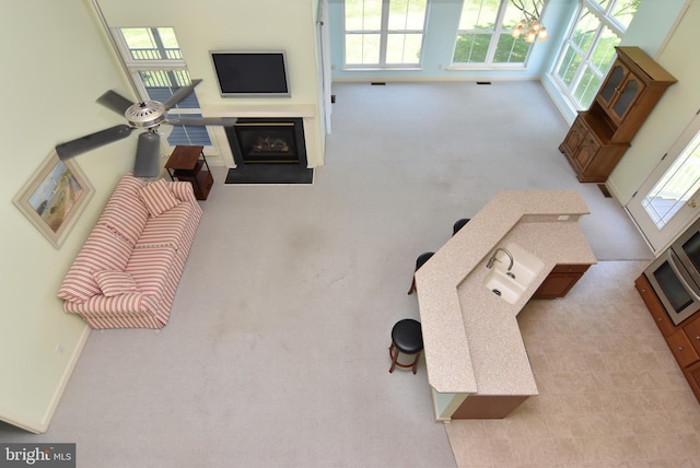 36765 Hummingbird Way N, Selbyville, DE 19975 - carpeted living area featuring plenty of natural light, a fireplace with flush hearth, and a chandelier