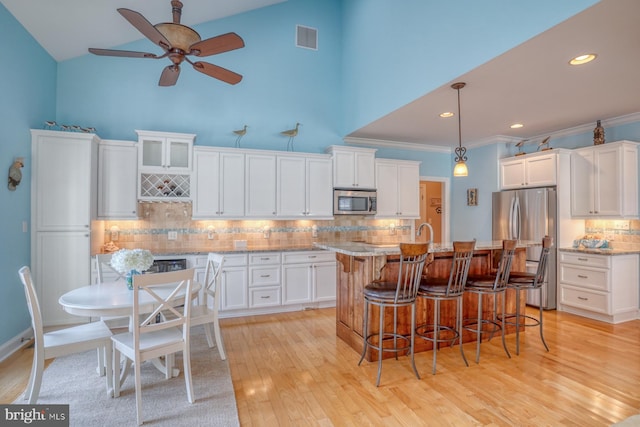 156 E Buckingham Dr, Rehoboth Beach, DE 19971 - kitchen featuring stainless steel appliances, backsplash, a ceiling fan, white cabinetry, and high vaulted ceiling