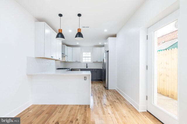 2713 E Huntingdon St, Philadelphia, PA 19125 - kitchen featuring freestanding refrigerator, a peninsula, light countertops, light wood-type flooring, and hanging light fixtures