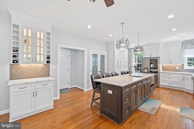 20736 Ashburn Station Pl, Ashburn, VA 20147 - kitchen featuring stainless steel fridge with ice dispenser, a kitchen breakfast bar, white cabinets, dark brown cabinets, and french doors