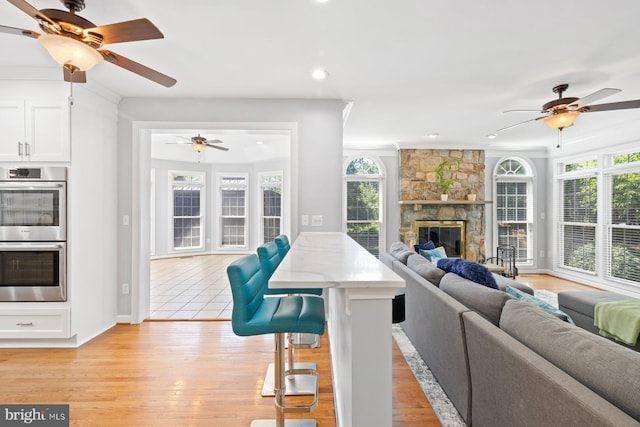 20736 Ashburn Station Pl, Ashburn, VA 20147 - living area with ceiling fan, recessed lighting, a stone fireplace, and light wood finished floors