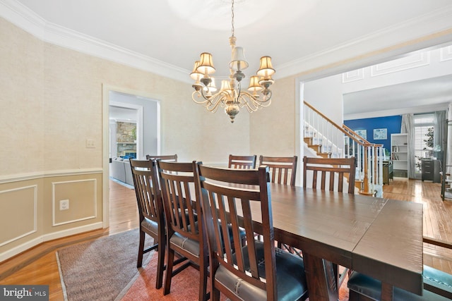 20736 Ashburn Station Pl, Ashburn, VA 20147 - dining space with wood finished floors, a chandelier, ornamental molding, stairs, and wainscoting