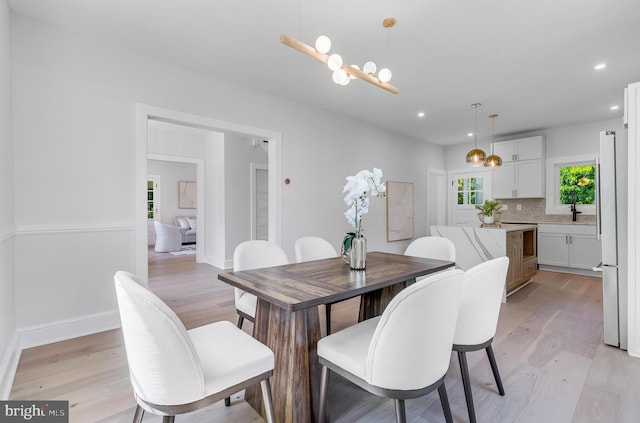 6818 Connecticut Ave, Chevy Chase, MD 20815 - dining room featuring light wood-type flooring, recessed lighting, and a chandelier