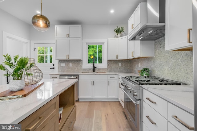 6818 Connecticut Ave, Chevy Chase, MD 20815 - kitchen featuring wall chimney range hood, stainless steel appliances, plenty of natural light, light wood-style floors, and recessed lighting