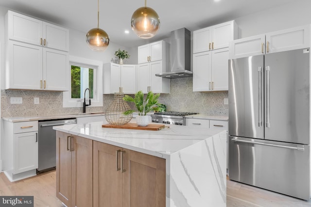 6818 Connecticut Ave, Chevy Chase, MD 20815 - kitchen with stainless steel appliances, wall chimney exhaust hood, light wood-style flooring, and light stone counters