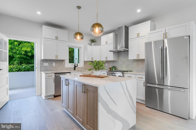 6818 Connecticut Ave, Chevy Chase, MD 20815 - kitchen with stainless steel appliances, wall chimney exhaust hood, backsplash, light wood finished floors, and light stone countertops